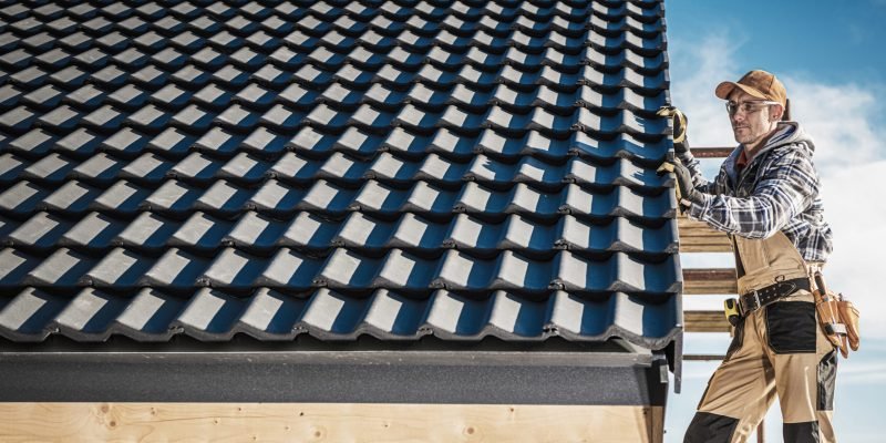 Ceramic Tiles Roof Building Performed by Construction Contractor Worker. Caucasian Roofer.
